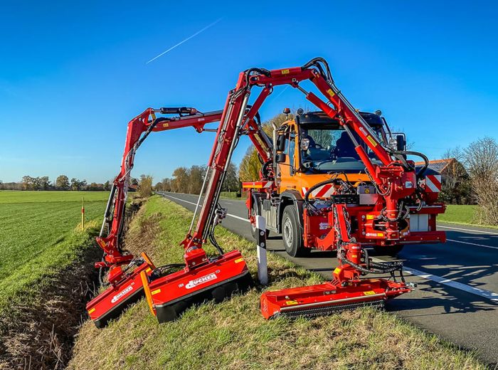 robuster Traktor mit großer Klinge steht am Straßenrand