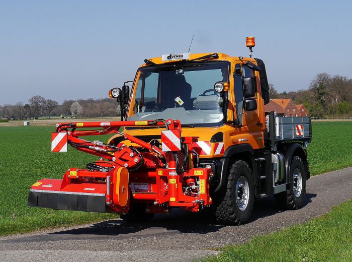 Ein großer orangefarbener Lastwagen fährt die Straße entlang, Modell: Duecker Una500.