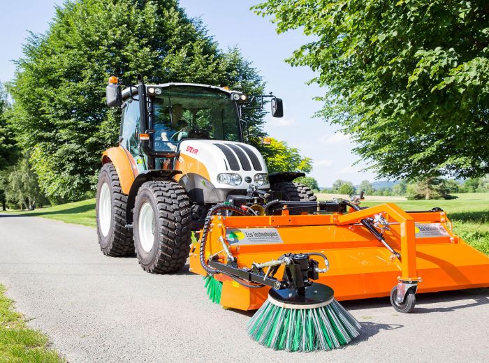 Ein Traktor mit einer Ecotech Kehrmaschine WS auf einer Straße, bereit zum Kehren und Reinigen der Fahrbahn