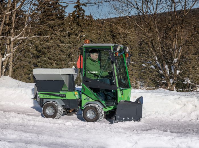 Ein Mann steuert eine grüne Egholm Snow vblade auf einer schneebedeckten Straße