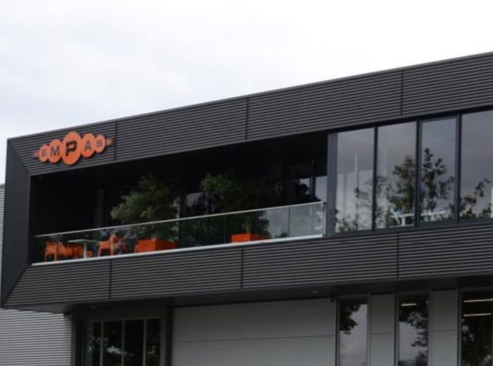 Empas Firmengebäude mit markantem Markenschild und großen Glasfenstern