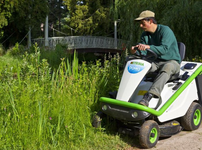 Effiziente Feldarbeit: Mann fährt Etesia Rasenmäher durch hohes Gras
