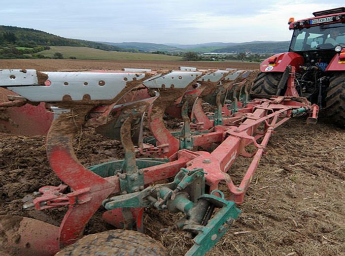 Traktor bei der Bodenbearbeitung: Pflügen eines Feldes mit GKB-Technologie für effiziente Landwirtschaft