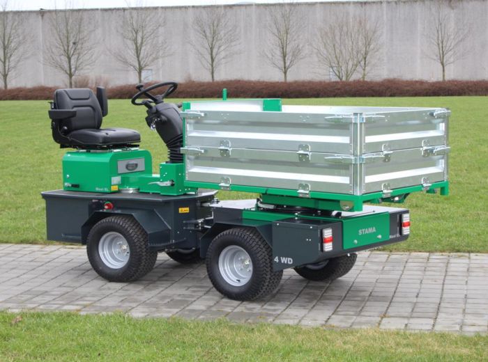 Kleines grünes Fahrzeug mit angehängtem Anhänger, beschriftet mit