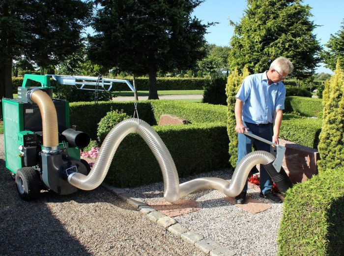 GMR Maskiner Reinigung: Ein Mann nutzt einen großen Schlauch zur Gartenreinigung