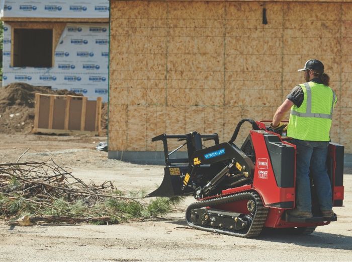 Ein Mann bedient eine rote Maschine, um Trümmer mit einem Grapplebucket SW23 5570S zu bewegen