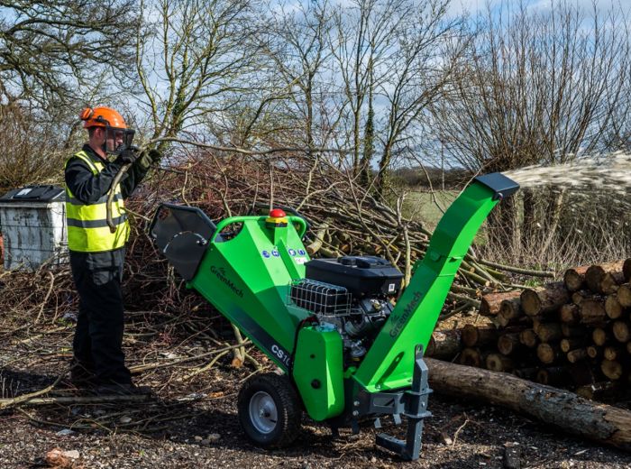Ein Mann nutzt einen Greenmech cs100 Kleinhäcksler, um Holzstämme effizient zu zerkleinern