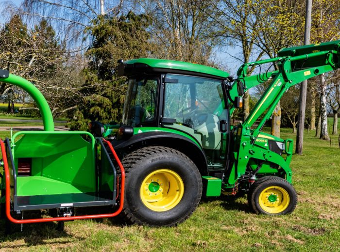 Grüner Traktor Greenmech Eco 150TMP mit großem grünen Eimer auf einem Feld