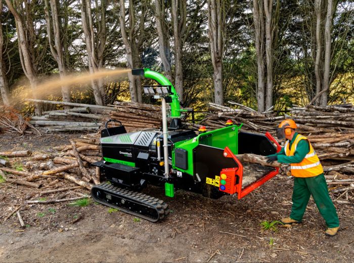 Ein Mann bedient eine Greenmech Evo 250D Sure Trak Maschine zum Holzschneiden