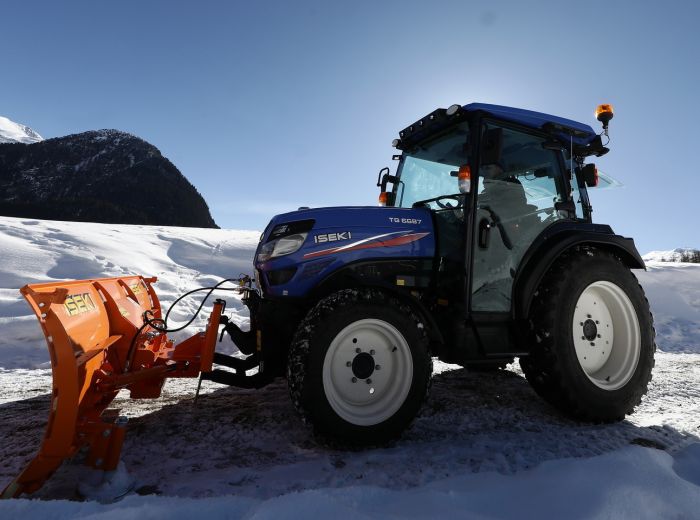 Blauer Iseki G6 Traktor mit Schneepflug auf dem Boden, ideal für winterliche Räumarbeiten