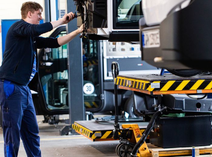 Ein Mann in der Iseki Werkstatt führt Wartungsarbeiten an einem Fahrzeug in der Garage durch