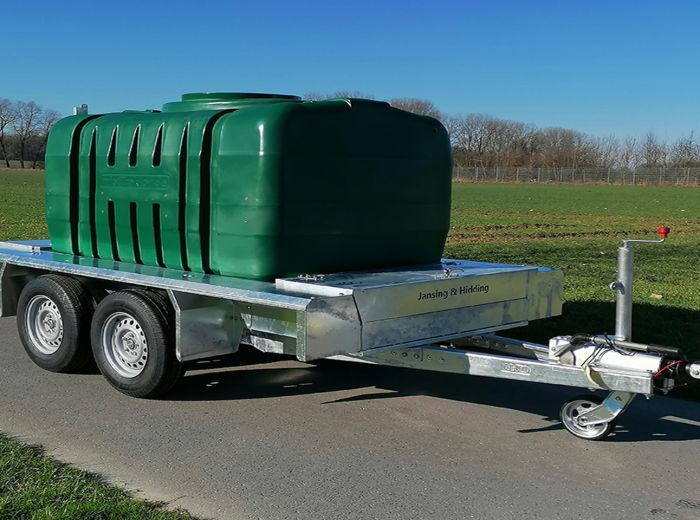 Anhänger mit grünem Tank von Jansing & Hidding, spezialisiert auf Bewässerungstechnik.