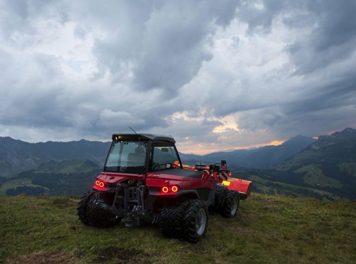 Roter Traktor, Modell Kalinke Aebi, steht auf einem Hügel in ländlicher Umgebung