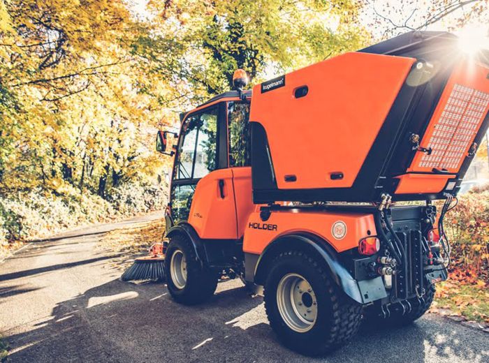 Eine große orange Maschine von Kugelmann Leiser Maschinen steht auf einer Straße.
