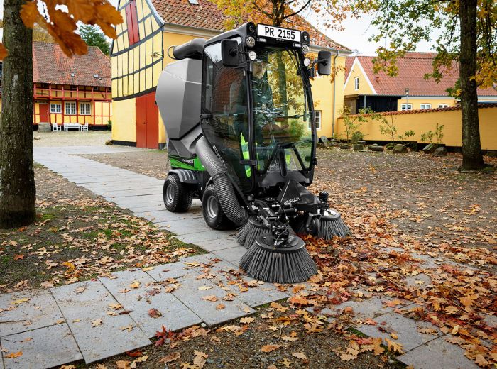 Eine Egholm 2155 Kehrmaschine fegt Blätter vom Boden und sorgt für Sauberkeit im Außenbereich