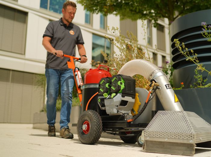 Ein Mann reinigt den Bürgersteig mit dem Wildkrautbeseitiger Zacho UKB 655 ego