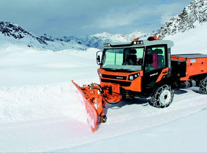 Ein Schneepflug räumt Schnee auf einem verschneiten Berg, um die Straße freizuhalten