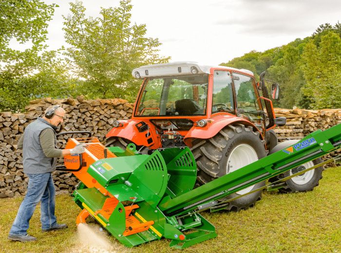 Ein Mann schneidet Holz mit der Posch Brennholzsäge Easycut 1733, während er einen Traktor bedient
