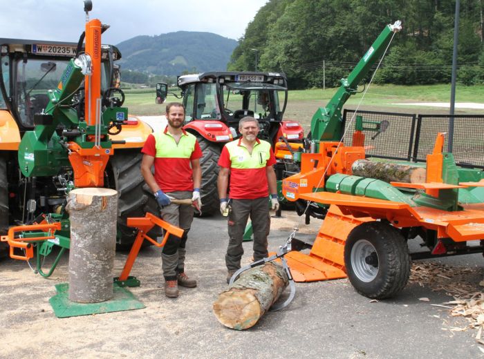 Zwei Männer stehen neben einem Traktor und einem Holzstamm, der mit dem Posch Holzspalter bearbeitet wird