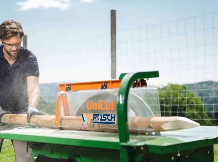 Ein Mann schneidet mit einer Posch Tischkreissäge Holzpfähle präzise und effizient