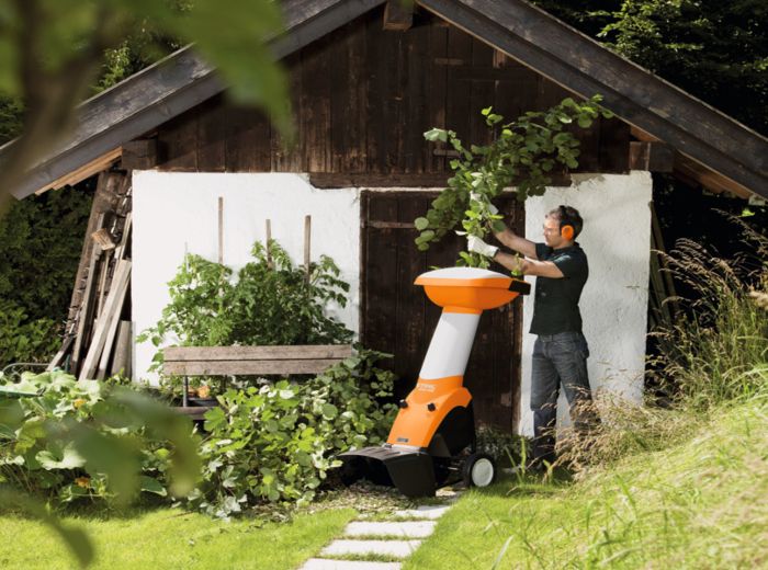 Ein Mann mäht mit einem Rasenmäher einen Baum, während er Stihl Gartenarbeit verwendet
