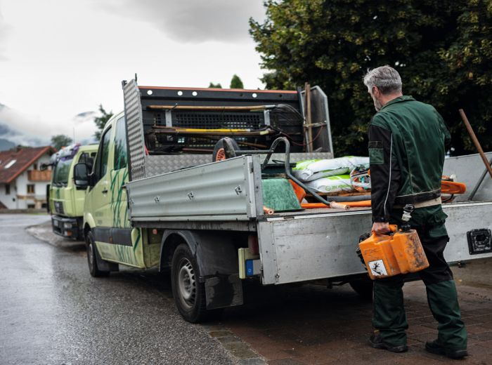 Ein Mann steht neben einem Lkw mit einer Werkzeugkiste, bereit für die Stihl Reparatur