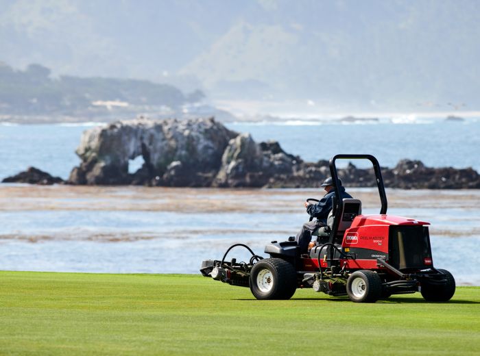 Ein Mann nutzt einen Toro Reelmaster Traktor, um einen Golfplatz zu mähen