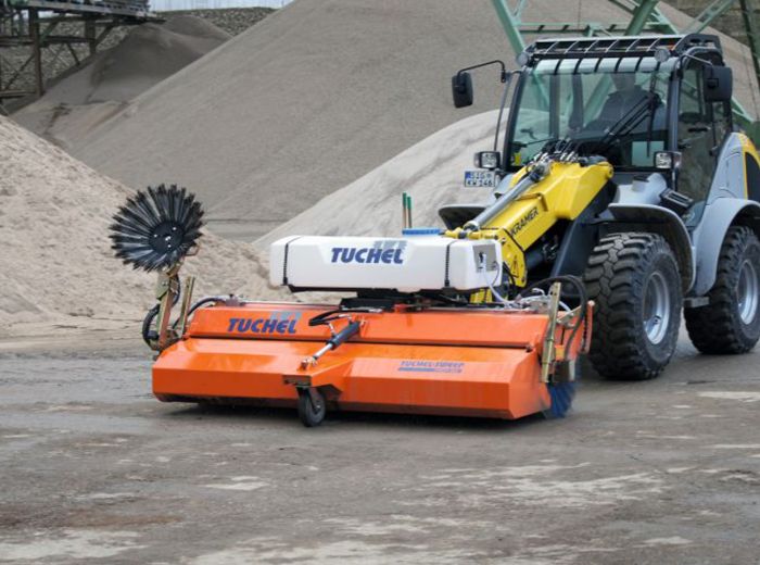 Traktor mit großem orangefarbenen Eimer auf dem Boden, ideal für landwirtschaftliche Arbeiten und Transporte