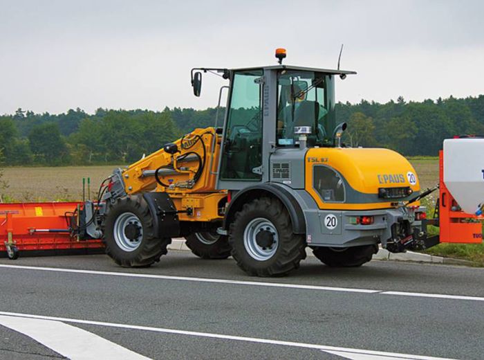 Traktor auf der Straße, ausgestattet mit einem Tuchel Salzstreuer für Winterdienst
