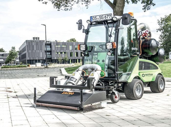 Eine grüne Maschine, Zacho Egholm 2150, steht auf einem gepflasterten Weg