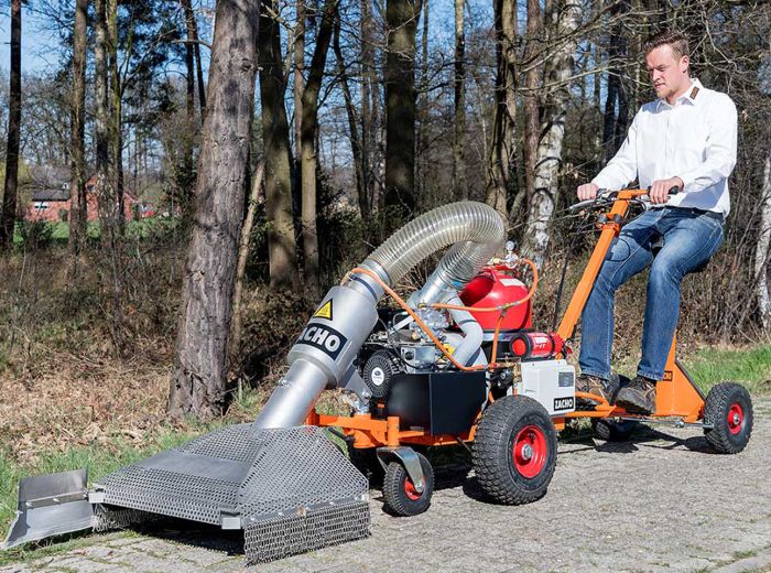 Ein Mann bedient eine kleine Maschine, um den Boden mit dem Zacho handgeführten Aufsitzer UKB zu reinigen