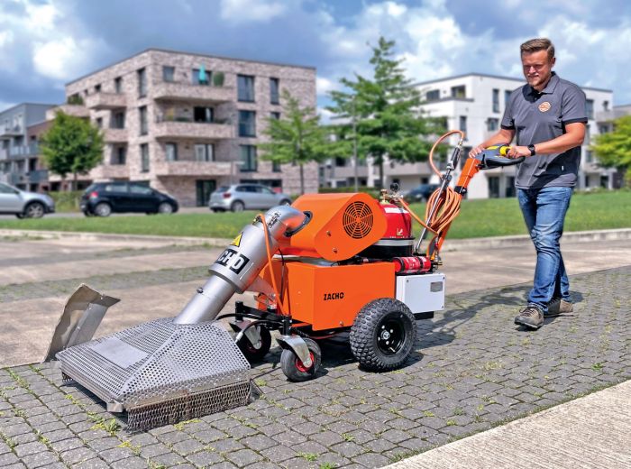 Ein Mann reinigt den Bürgersteig mit der Zacho UKB 655 E, einer kompakten Reinigungsmaschine